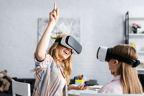 Selective focus of positive woman in vr headset having idea near kid at home