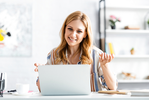 Selective focus of woman smiling and talking during webinar