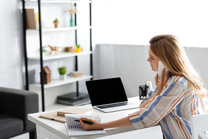 Selective focus of pretty woman working with laptop and digital device
