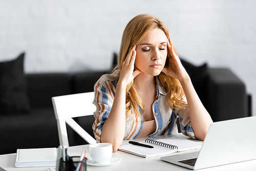 tired woman having headache at workplace at home