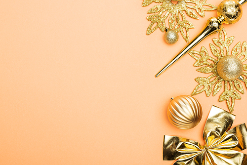top view of golden Christmas decoration on orange background with copy space