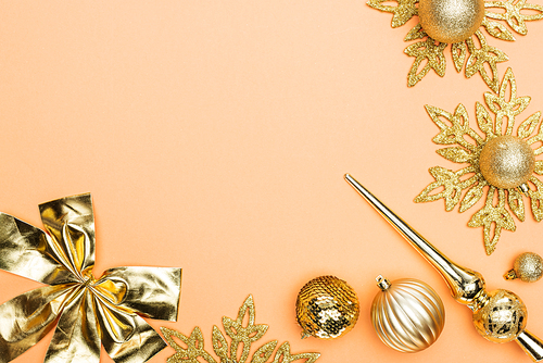 top view of golden Christmas decoration on orange background with copy space