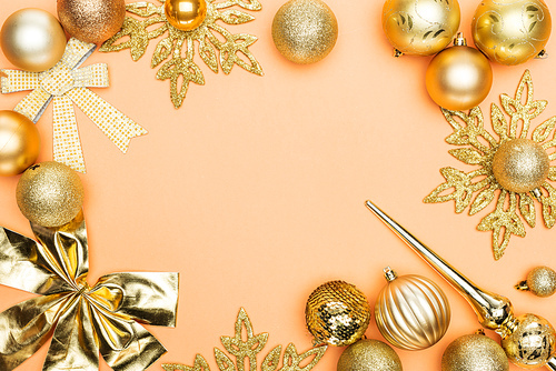 frame of golden christmas decoration on orange background with copy space