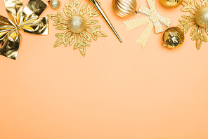 top view of festive golden christmas decoration on orange background with copy space