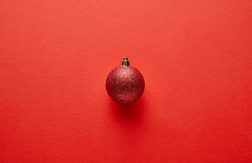 top view of shiny Christmas bauble on red background