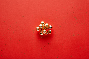 top view of shiny golden Christmas decoration on red background with copy space