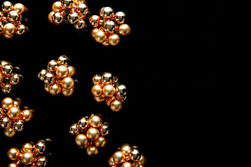 top view of shiny golden Christmas decoration isolated on black with copy space