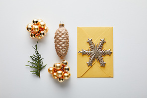 top view of shiny Christmas decoration, fir branch and envelope on white background