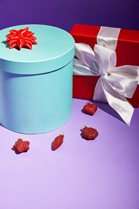 blue and red gift boxes near baubles on purple background