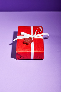 red gift box with bauble on violet background