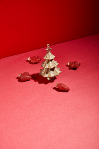 decorative golden Christmas tree with baubles on red background