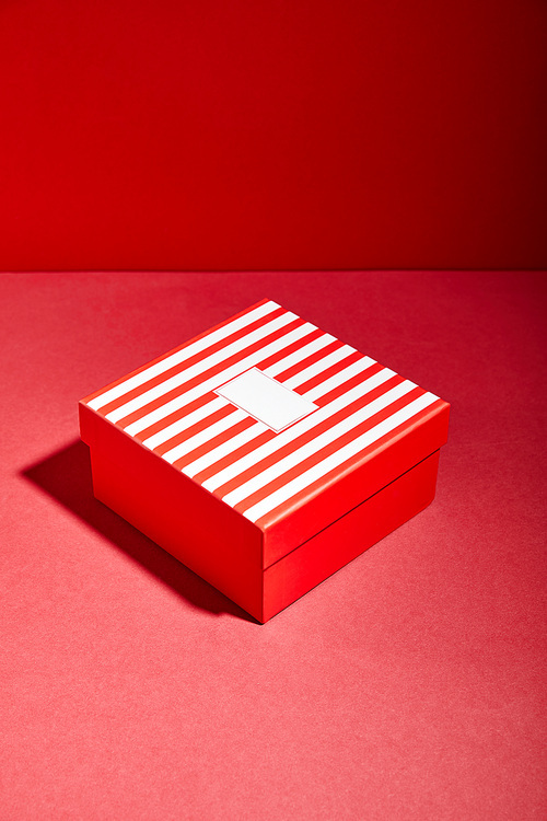 striped red gift box on red background