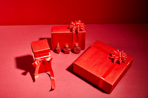 red wrapped festive gift boxes with ribbons and bows on red background