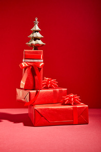 red gift boxes and decorative golden Christmas tree on red background