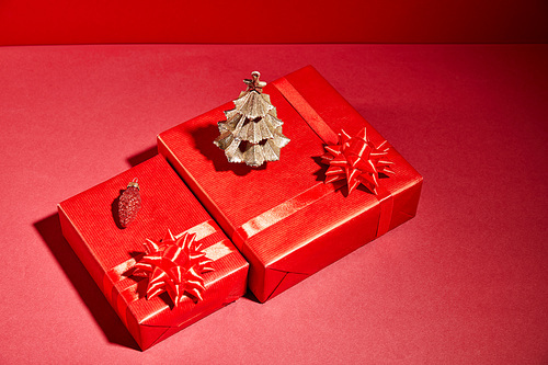 red gift boxes and decorative golden Christmas tree on red background
