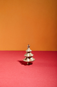 golden decorative Christmas tree on red and orange background