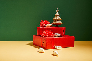 red gift boxes and golden Christmas decor on yellow and green background
