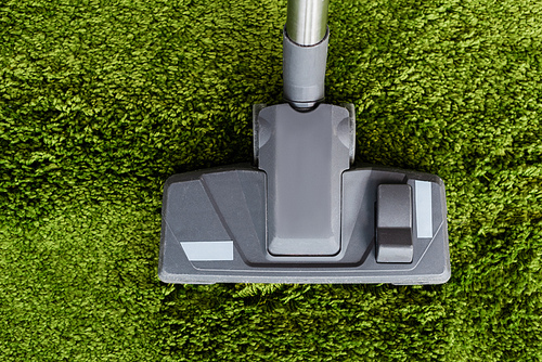 Top view of brush of vacuum cleaner on carpet at home