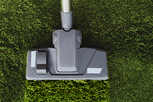 Top view of vacuum cleaner on dirty green carpet at home