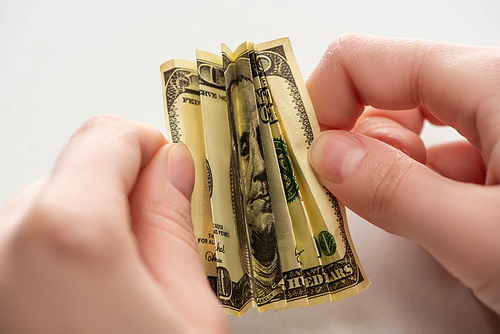 selective focus of woman holding crumpled dollar banknote in hands isolated on white