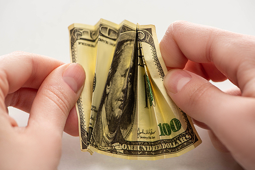 close up of woman holding crumpled dollar banknote in hands isolated on white