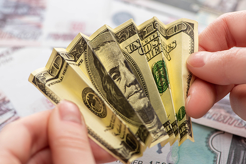 cropped view of woman holding crumpled dollar banknote in hands