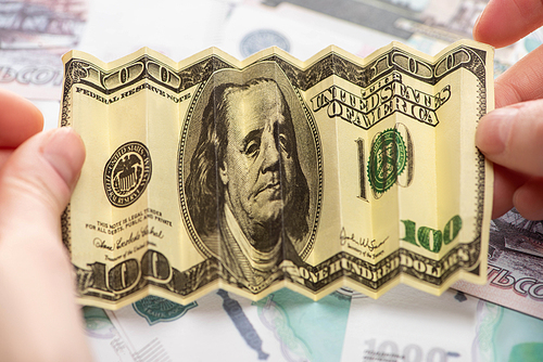 cropped view of woman holding crumpled dollar banknote