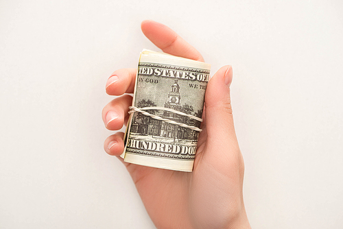 top view of woman holding cash roll isolated on white