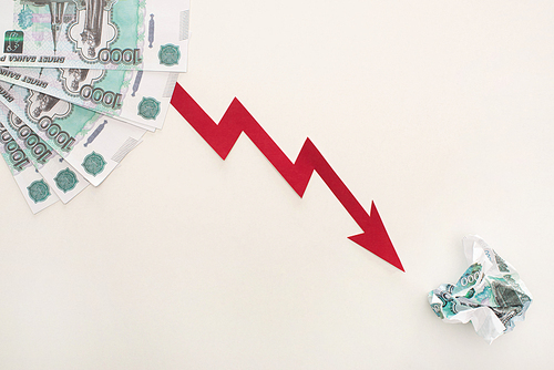 top view of crisis graph near ruble banknotes isolated on white