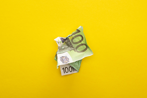 top view of crumpled euro banknote isolated on yellow