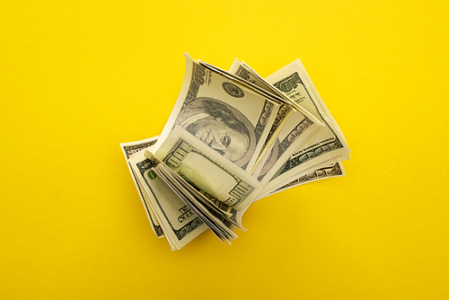 top view of dollar banknotes isolated on yellow