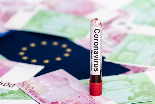 selective focus of euro banknotes, European flag and coronavirus blood sample