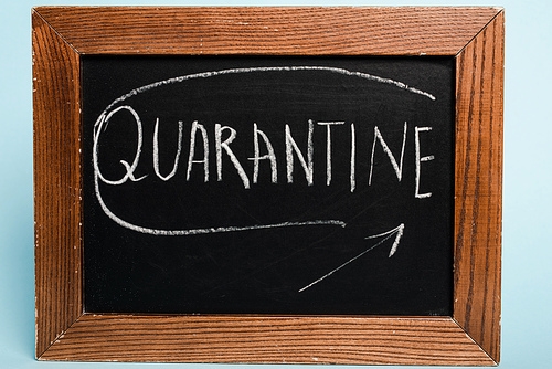 quarantine lettering written on chalkboard on blue background, coronavirus concept