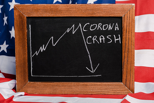 corona crash lettering written on chalkboard on american flag background, coronavirus concept