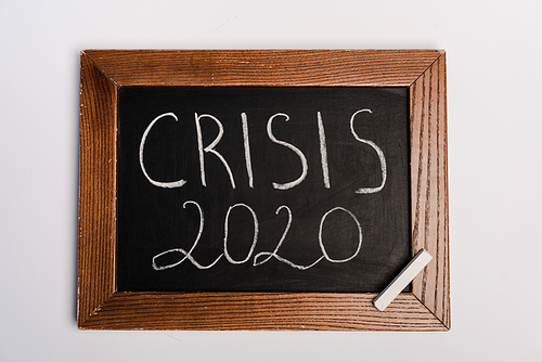 crisis 2020 lettering written on chalkboard on white background, coronavirus concept