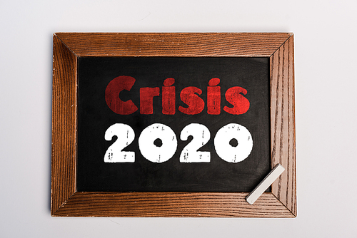 crisis 2020 lettering written on chalkboard on white background, coronavirus concept