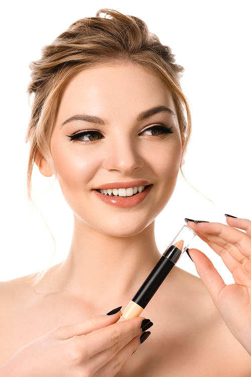 smiling naked beautiful blonde woman with makeup and black nails holding stick concealer isolated on white