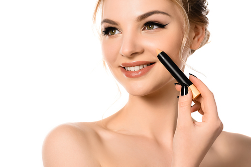smiling naked beautiful blonde woman with makeup and black nails applying stick concealer isolated on white