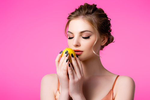 elegant beautiful blonde woman with closed eyes holding ripe lemon isolated on pink