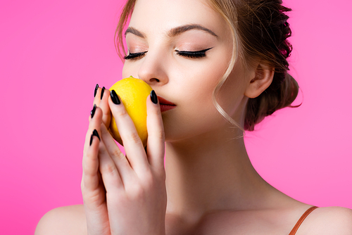 beautiful blonde woman smelling ripe lemon isolated on pink