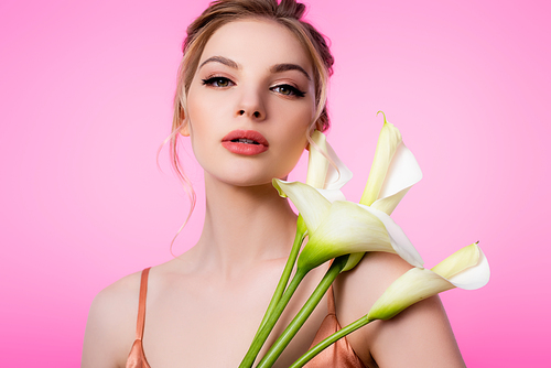 elegant beautiful blonde woman holding calla flowers isolated on pink