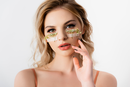 beautiful blonde woman with wildflowers under eyes isolated on white