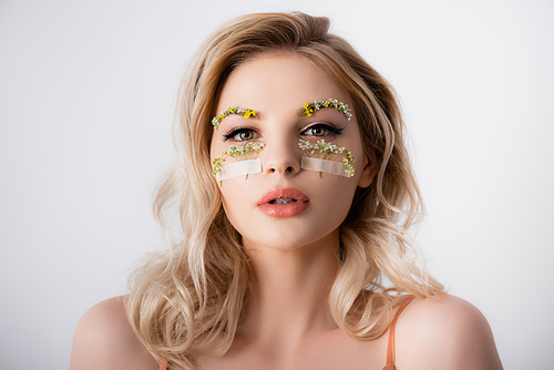 beautiful blonde woman with wildflowers under eyes isolated on white