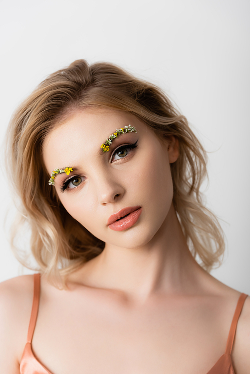 beautiful blonde woman with wildflowers on eyebrows  isolated on white