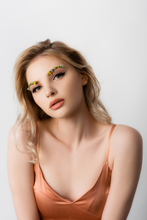 beautiful blonde woman in silk dress with wildflowers on eyebrows isolated on white