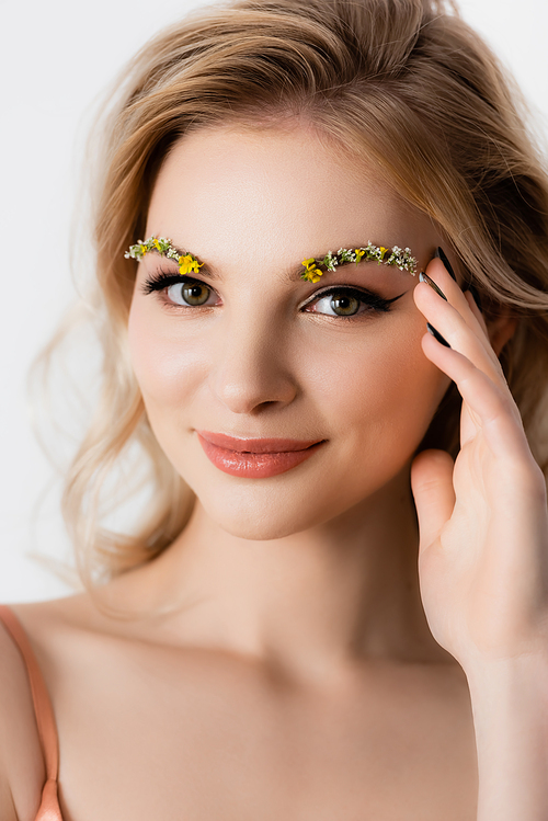 smiling beautiful blonde woman with wildflowers on eyebrows isolated on white