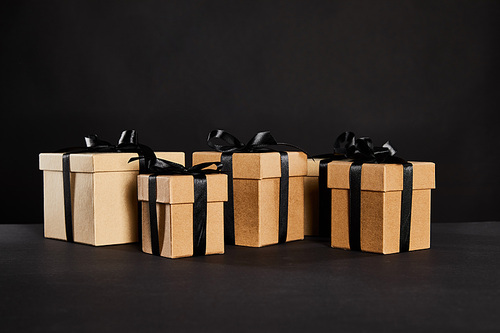 cardboard gift boxes with black ribbons isolated on black, black Friday concept
