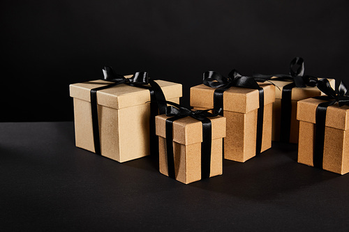 cardboard gift boxes with black ribbons isolated on black, black Friday concept