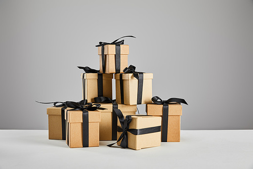 cardboard gift boxes with black ribbons isolated on grey, black Friday concept