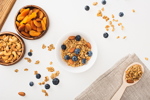 top view of delicious granola with nuts, blueberry and dried apricots isolated on white